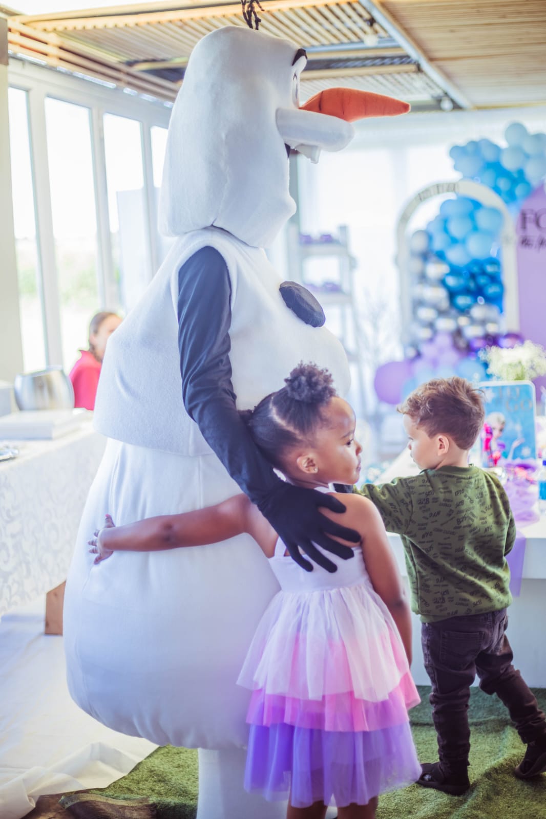 Olaf giving a party guest a big warm hug